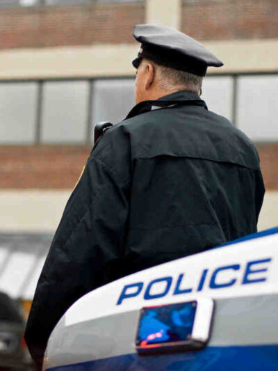 Officer leaning against car