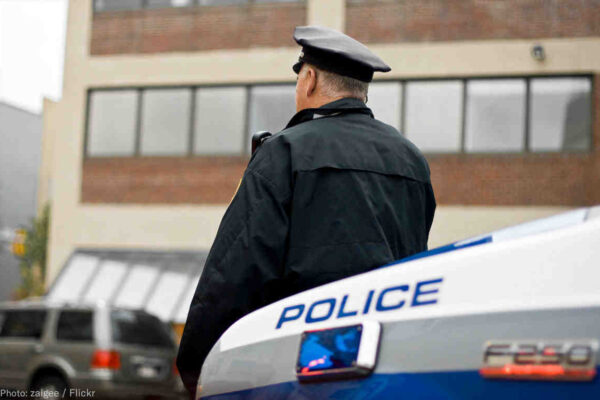 Officer leaning against car