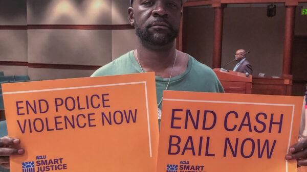 ACLU of Texas supporter with "End Cash Bail Now" sign