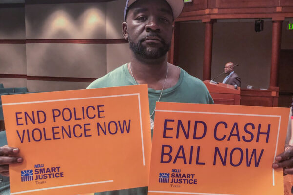 ACLU of Texas supporter with "End Cash Bail Now" sign