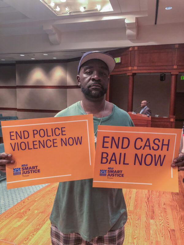 ACLU of Texas supporter with "End Cash Bail Now" sign
