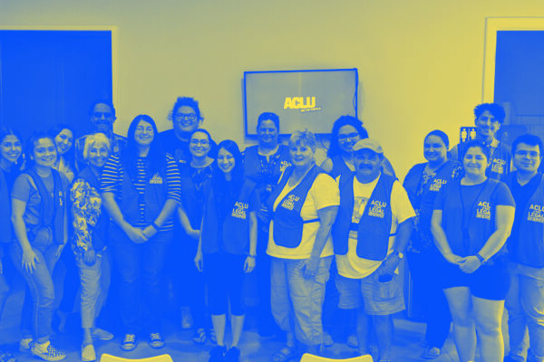 Image: A group people wearing vests that say 'ACLU of Texas Legal Observer' pose for the camera. Below them text reads Dallas Legal Observer Training / Union Coffee Dallas 3705 Cedar Springs Rd / November 16 | 2- 3:30pm.