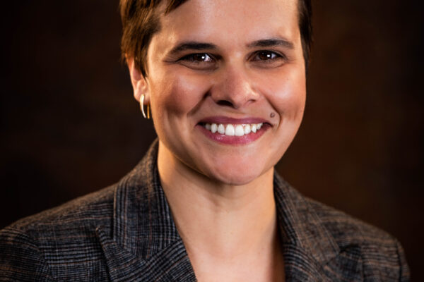 Image: A photo shows Sarah Labowitz posing for the camera in front of a solid background.