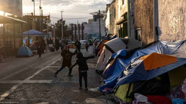 Two boys running around and playing outside of tents in Ciudad Juarez, Mexico.