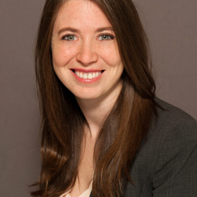 A photo shows Drucilla Tigner posing for a portrait in front of a solid background