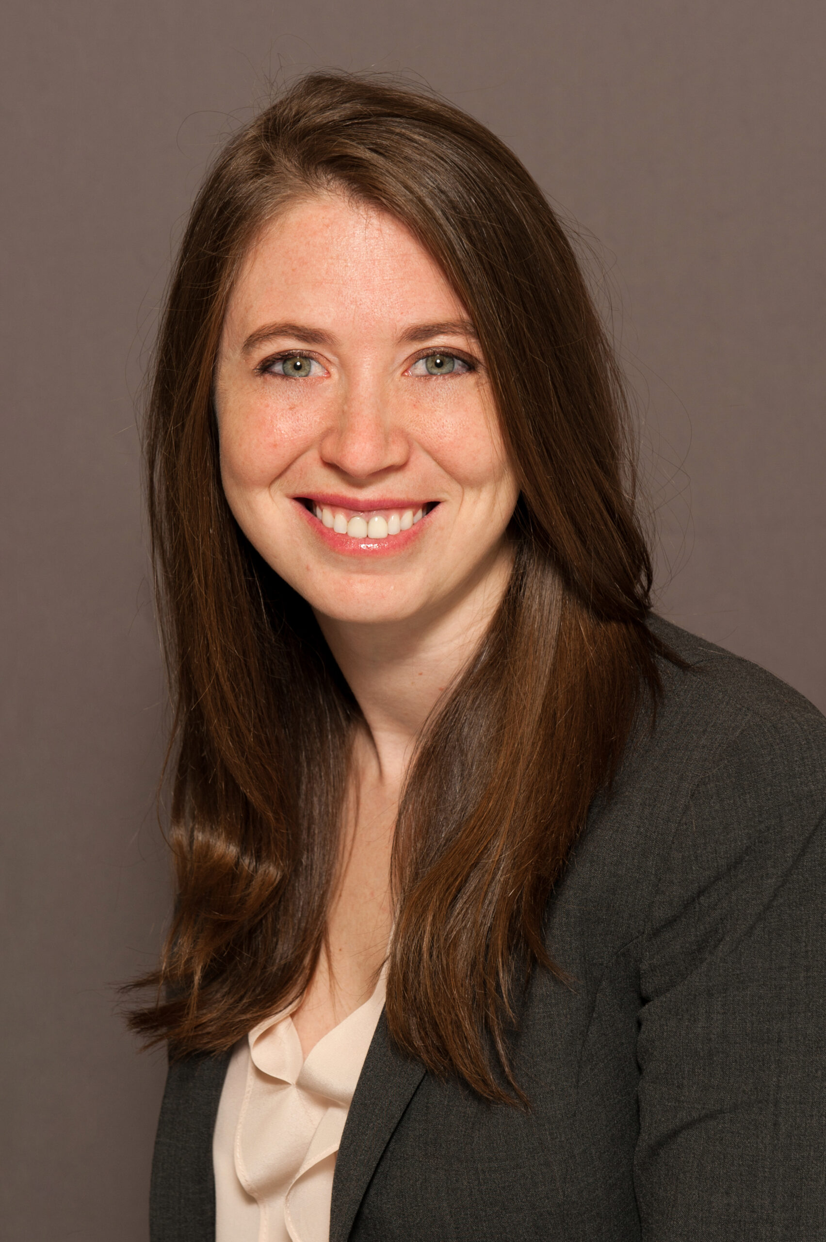 A photo shows Drucilla Tigner posing for a portrait in front of a solid background