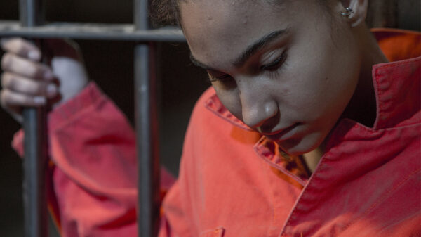 person holding on to bars with orange suit