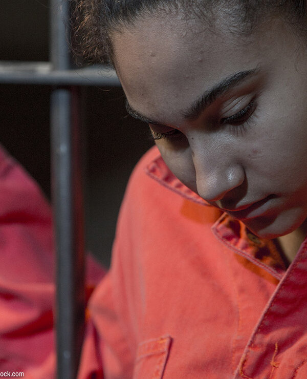 person holding on to bars with orange suit