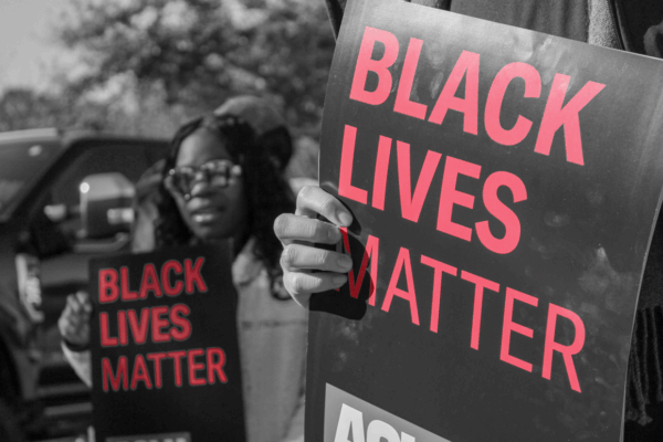 Image: A stylized photo shows people holding "Black Lives Matter" posters