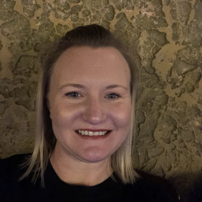 Photo: Lauren Coffee poses for a photo in front of a textured background.