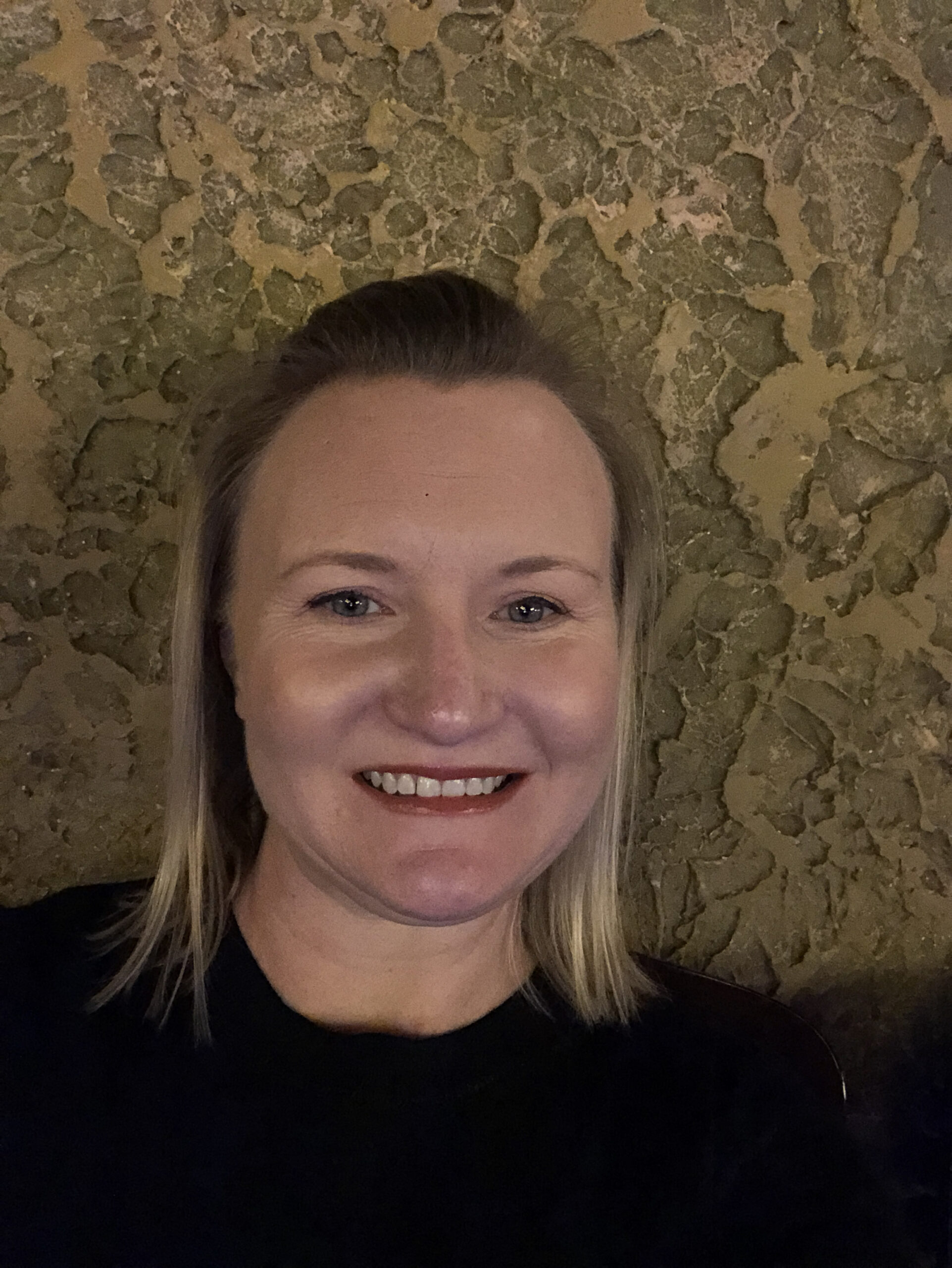 Photo: Lauren Coffee poses for a photo in front of a textured background.