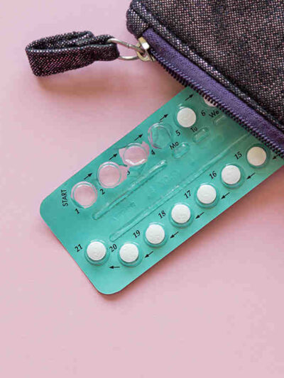 Photo: An aluminum packet of small circular pills has a few missing, the spots where they were punched out of the aluminum visible. The packet peacks out of a zipper pouch.