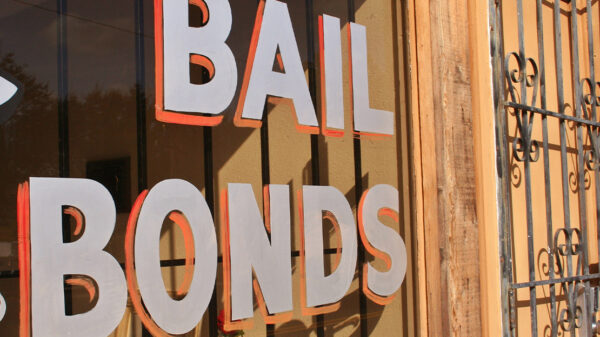 Image of a hand painted sign that reads "Bail Bonds" on a window