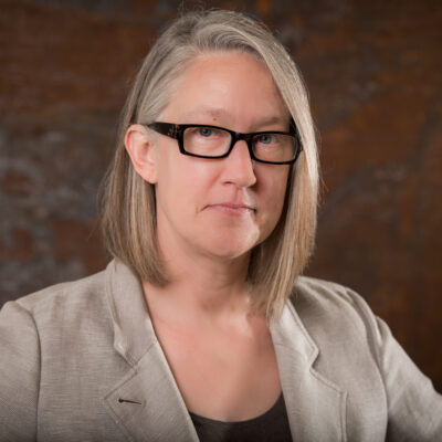 Photo: Rebecca Robertson poses for a photo in front of a textured background.