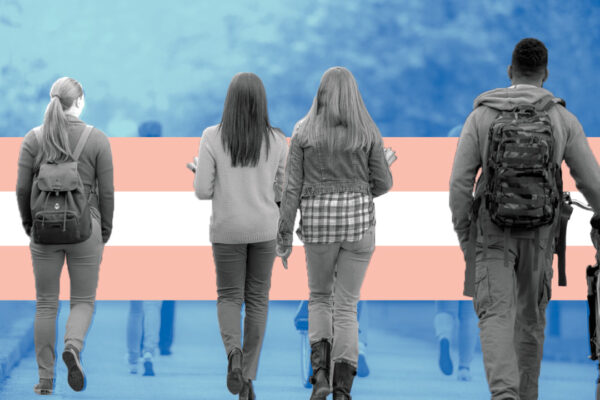 children walking with a trans flag in the background