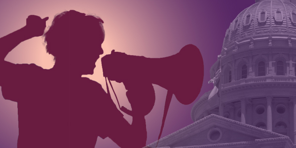 A silhouette of a person with a bullhorn in front of the Texas Capitol