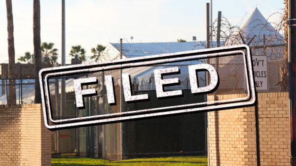 Exterior of migrant detention facility with the word "filed" stamped over the image.