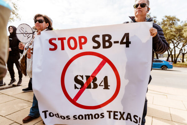 Supporters holding a "stop S.B. 4" banner rally at the Texas Capitol.