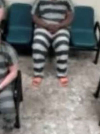 A cell door in a prison being locked by a gloved officer.