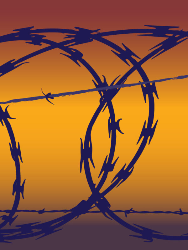 Barb wire in front of a yellow and orange hued background