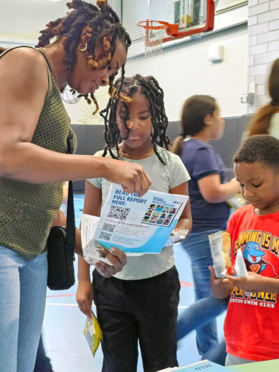 An adult and two children learn about the Students' Rights Hub