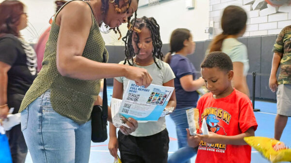 An adult and two children learn about the Students' Rights Hub