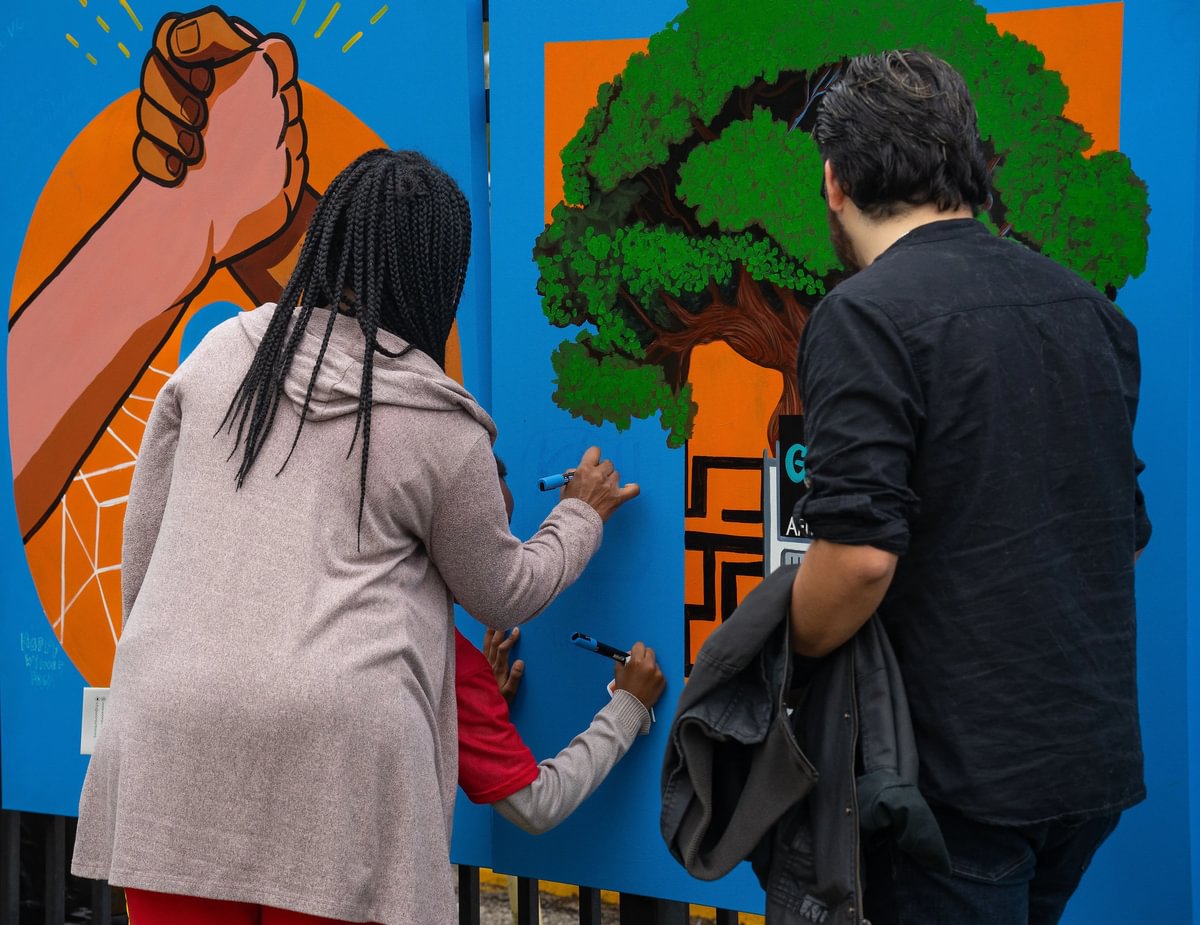 Residents help paint a mural in Gulfton