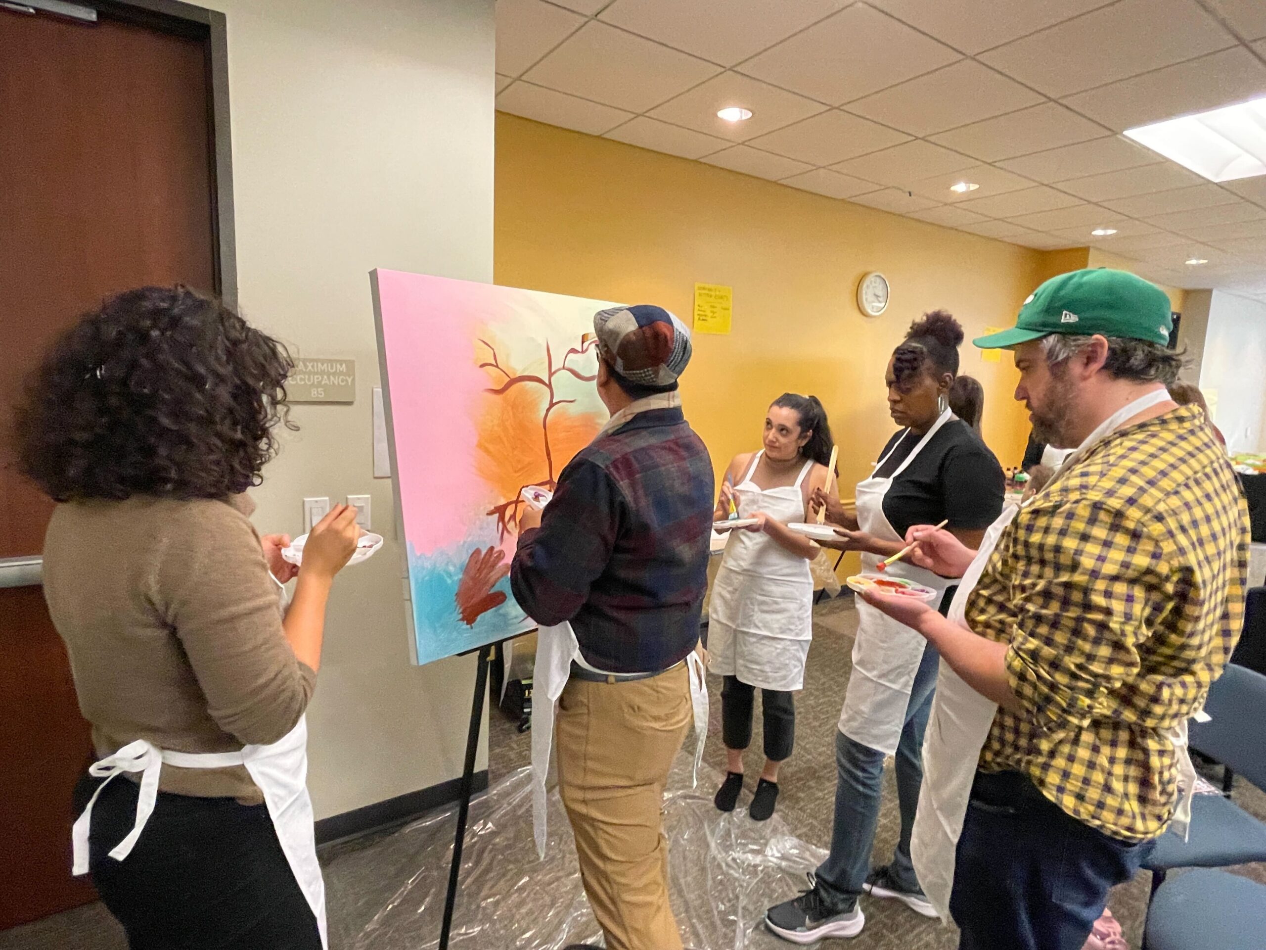 Staff paint a canvas depicting their vision for voting rights