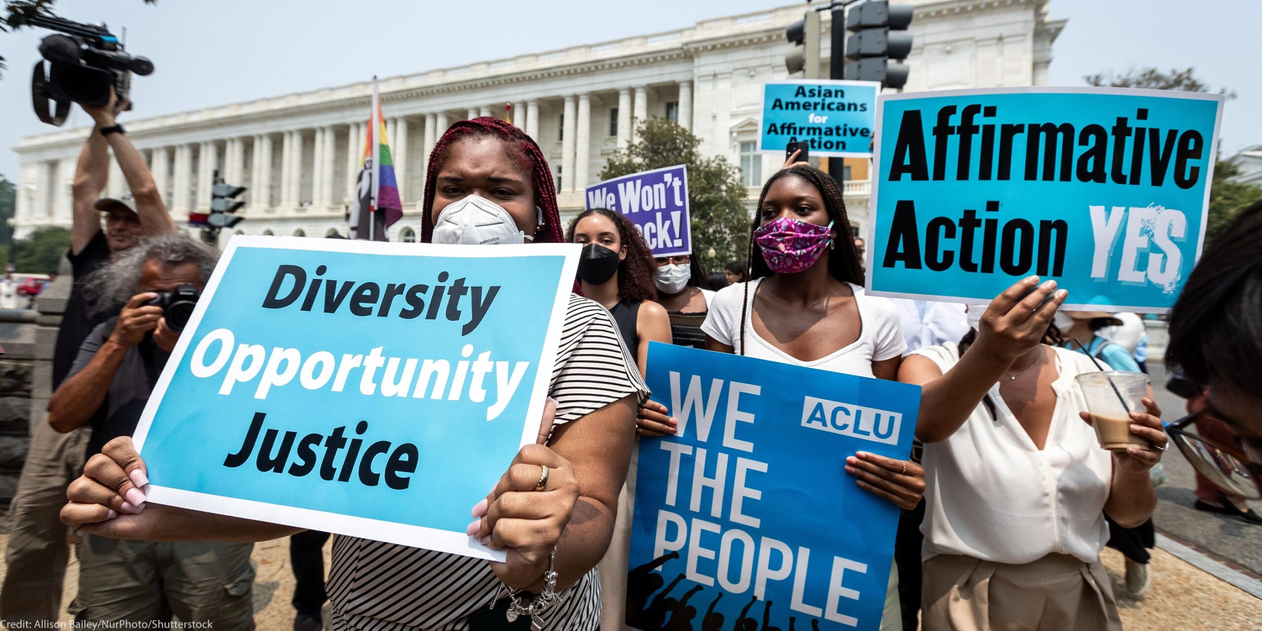 Protesters in front of the Supreme Court hold signs that read, "Diversity, Opportunity, Justice", "ACLU, WE THE PEOPLE", "Affirmative Action YES!" and "Asians for Affirmative Action".