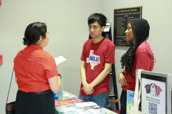 image of two people tabling and wear an aclu of tx t shirt