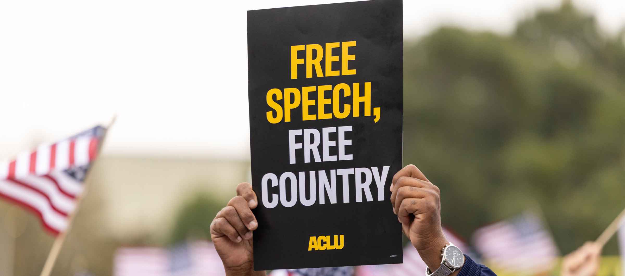 Close up photo of an ACLU protest sign that reads "Free Speech, Free Country"