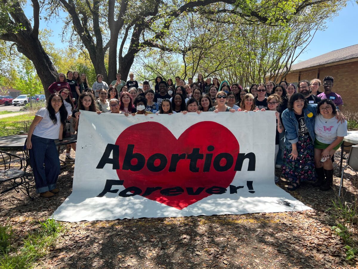 Large group of people holding a sign that says Abortion Forever