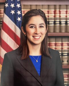 image of caro rivera nelson in front books and american flag