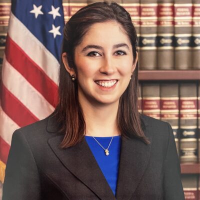 image of caro rivera nelson in front books and american flag