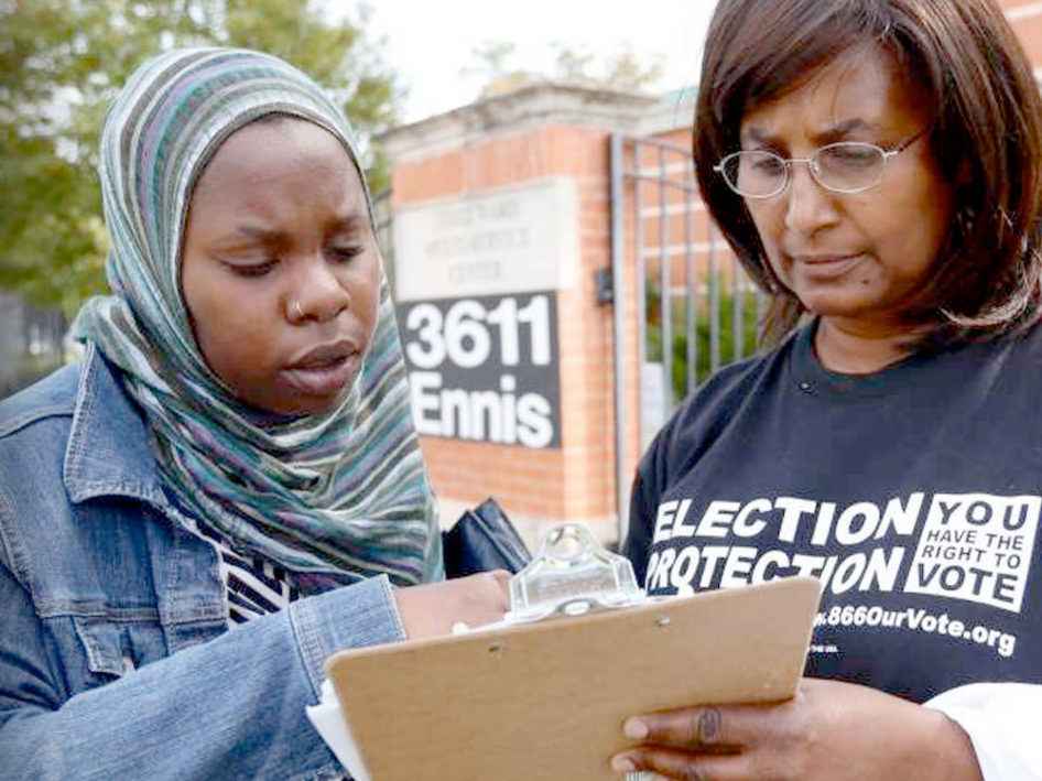 A poll monitor helps a voter