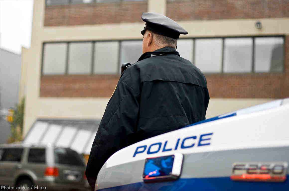 Officer leaning against car