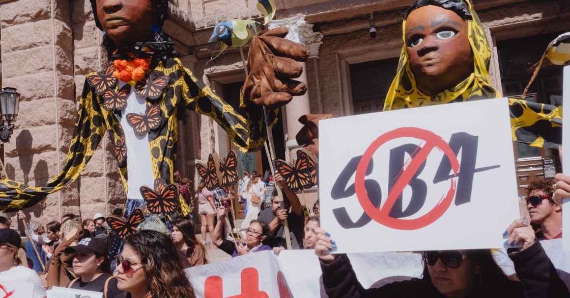 Image of puppets at a rally against SB4 and a sign that reads no sb4 is visible