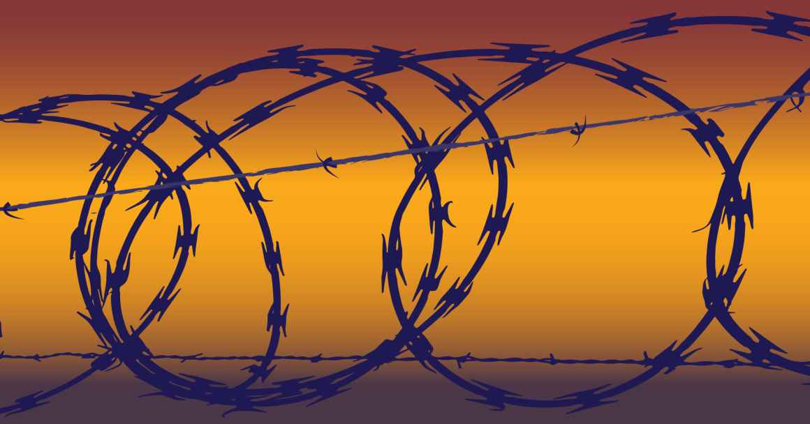 Barb wire in front of a yellow and orange hued background