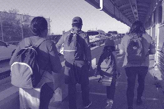 Image: A stylized photo shows a family, their backs to the camera, carrying backpacks and walking along the international bridge between Matamoros in Mexico and Brownsville, TX. 