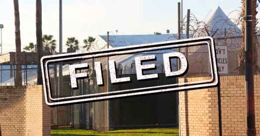 Exterior of migrant detention facility with the word "filed" stamped over the image.