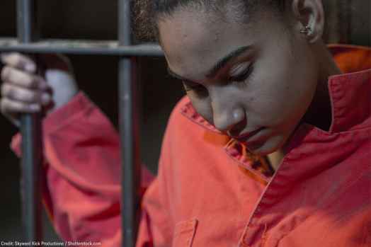 person holding on to bars with orange suit