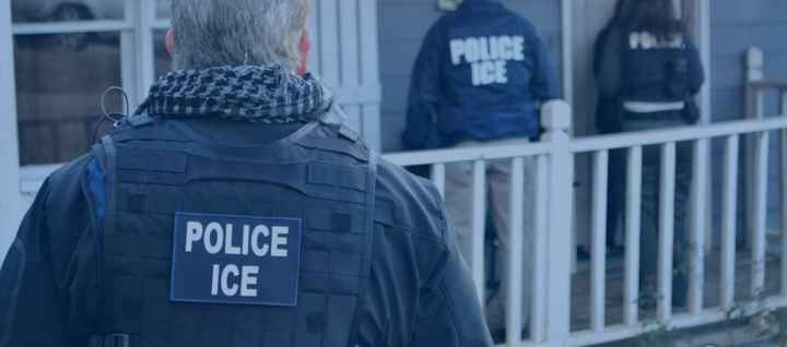 image of an ice agent from behind with his vest reading POLICE ICE