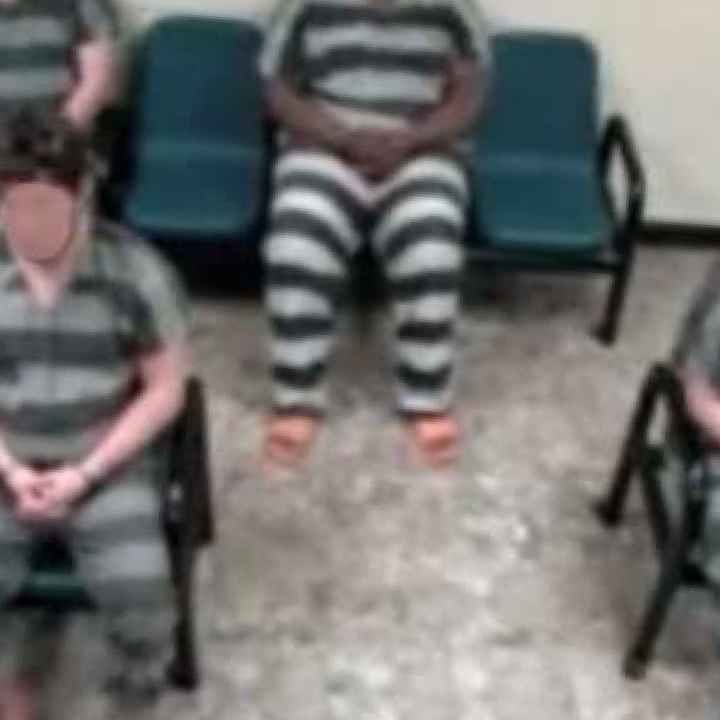 A cell door in a prison being locked by a gloved officer.