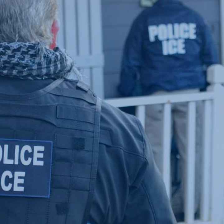 image of an ice agent from behind with his vest reading POLICE ICE