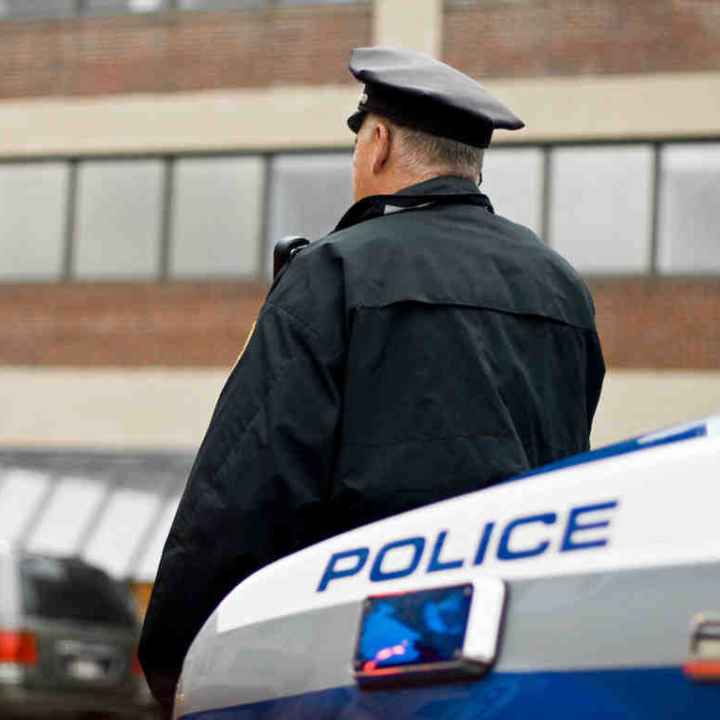 Officer leaning against car